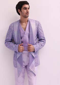 Elevate your evening ensemble with our expertly crafted three-piece tuxedo set. Crafted on a glamorous shimmer base. This lavender tuxedo is ornate with hand embroidered cutdana work and lapel detailing. Complemented with a pleated shirt and straight pants. This glitzy outfit will command everyone's attention. Dry-clean only if required. Slight variation in color is possible due to digital photography. Luxury Lavender Traditional Wear For Diwali, Lavender Tuxedo, Lavender Wedding Mens Wear, Carnival Outfit For Men, Lavender Jodhpuri Suits For Men, Lavender Sherwani For Groom, Lavender Kurta Men, Lilac Kurta For Men, Manish Malhotra Menswear