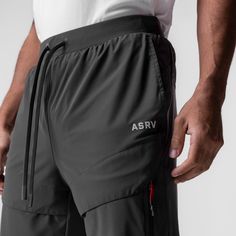 a man wearing grey shorts and white t - shirt with the word asrv on it