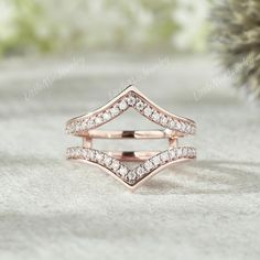 two rose gold wedding rings with diamonds on top and bottom, sitting on a white surface