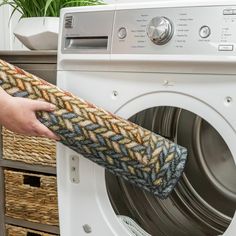 a person holding a towel over a washing machine