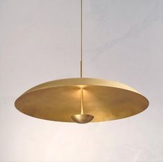 a large brass pendant light hanging from a ceiling