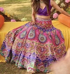 a woman in a colorful skirt is posing for the camera