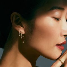 An Asian woman with her hair pulled away wears a cascade of diamond earrings. The dramatic shadow that casts just above her brow gives the photo an old hollywood kind of drama. Yellow Gold Diamond Earrings For Evening, Luxury Yellow Gold Drop Diamond Earrings, Fine Jewelry Teardrop Diamond Earrings For Evening, Evening Teardrop Diamond Earrings, Fine Jewelry Rose Cut Diamond Earrings For Evening, Elegant Rose Cut Diamond Drop Earrings, Luxury Sparkling Yellow Gold Diamond Earrings, Elegant Diamond Briolette Earrings, Elegant Yellow Gold Drop Diamond Earrings