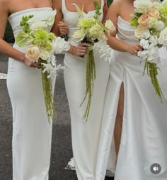 three bridesmaids in white dresses holding bouquets