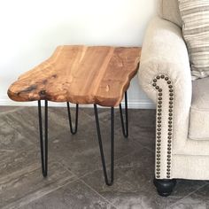 a wooden table sitting on top of a floor next to a white couch and chair