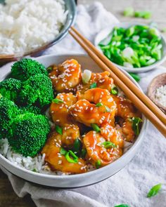 a bowl filled with chicken and broccoli on top of rice next to chopsticks