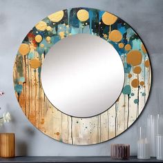 a round mirror sitting on top of a wooden table next to a vase with flowers