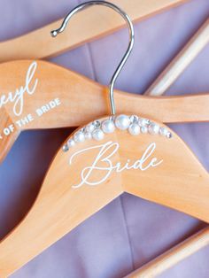 a wooden hanger with the word bride written on it