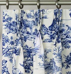 blue and white toiler curtains hanging on a curtain rod