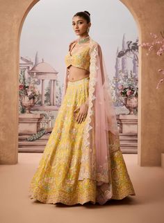 Step into refined elegance with this vibrant yellow lehenga adorned with intricate floral baroque patterns. Embellished with resham, gotapatti, and shimmering sequins, each detail reflects timeless craftsmanship. Paired with a striking pink dupatta, this ensemble offers a harmonious blend of tradition and modern charm, perfect for the sophisticated woman. Designer Yellow Anarkali Set With Intricate Embroidery, Yellow Semi-stitched Gown With Intricate Embroidery, Semi-stitched Yellow Gown With Intricate Embroidery, Yellow Sets With Mirror Work In Traditional Drape, Yellow Elegant Lehenga With Sheer Dupatta, Yellow Traditional Drape Sets With Mirror Work, Yellow Traditional Drape Set With Mirror Work, Elegant Yellow Lehenga With Sheer Dupatta, Festive Yellow Sets With Intricate Embroidery