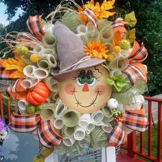 a scarecrow wreath with pumpkins and leaves