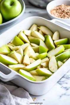 green apples in a white casserole dish next to bowls of oatmeal