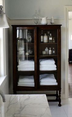 a bathroom with marble counter tops and white towels on the shelves in front of it