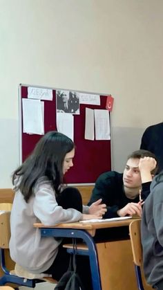 two students sitting at desks in a classroom