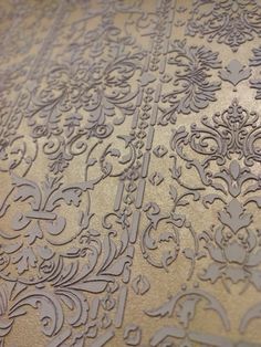 an intricate design is shown on the surface of a table top, which has been painted gold