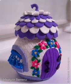 a purple and white toy house with flowers on it