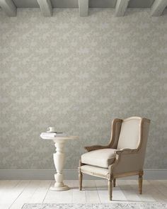 an old chair and table in front of a wallpapered room with white floors