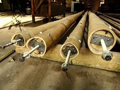 several pipes are lined up on the floor in an industrial area with metal rods and screws