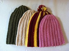 four knitted beanies lined up on top of each other