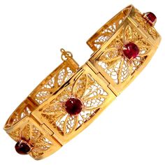 7.40ct. Natural Cabochon Spinels bracelet. Vintage Open Gilt Design Vivid Red colors. Transparent & Clean Clarity. Average 5.7mm No Enhancements & Fully Natural. 14kt. Yellow gold 37 Grams. 5.5mm wide bracelet 7.25 inches long (wearable length) 17mm wide links. Ancient Style - Pull Bar Locking $9,500 Appraisal Certificate will accompany.