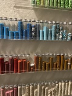 the shelves are filled with different colored spools of thread