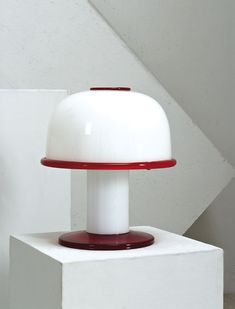 a white lamp sitting on top of a table next to a stair case in a room