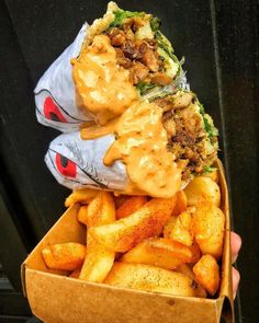 a box filled with fries covered in cheese sauce