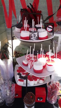 three tiered trays filled with cupcakes and candy