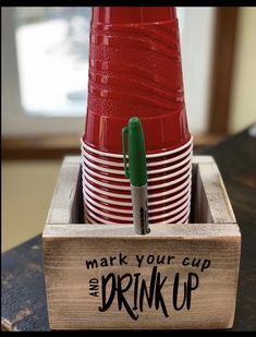 a stack of red cups sitting inside of a wooden box on top of a table