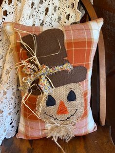 a pillow with a scarecrow face on it sitting on a chair next to a lace doily