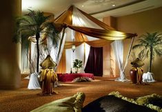 a room decorated in gold and white with palm trees