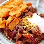 a white plate topped with chili and tortilla chips