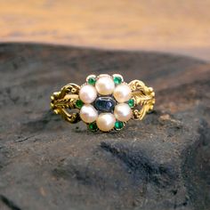 This lovely antique ring feature Moonstone decorated with Pearls accented with Emeralds crafted in 14ct. Design Era: Early Victorian (1837-1855). Size: 16.71 NL / 52.5 FR / 6¼ US / M UK Dimensions: H 0.4 X L 1 x W 1 cm. Weight in grams: 3,5. Condition: Very good condition - slightly used with small signs of wear. Resizing possible (contact seller for information). Registered Shipping or Local Pickup at our store (in case of Local Pickup; shipping cost if applicable will be refunded). Looking for Victorian Oval Pearl Ring With Gemstone, Victorian Pearl Ring Gemstone Gift, Victorian Pearl Ring With Gemstone For Gift, Victorian Moonstone Gemstone Ring For Wedding, Victorian Pearl Ring Gift, Victorian Style Pearl Ring Gift, Victorian Moonstone Cabochon Ring For Wedding, Victorian Moonstone Ring For Anniversary, Heirloom Multi-stone Pearl Ring As Gift