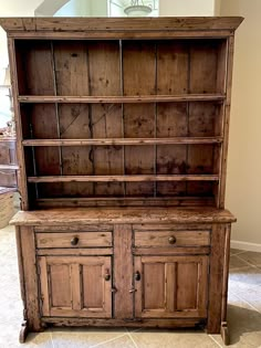 an old wooden hutch sitting on top of a tiled floor