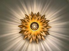 a light that is on the side of a wall with a flower shaped lamp in it