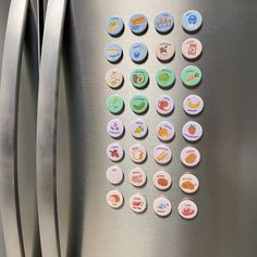 a stainless steel refrigerator with several different magnets on the front and back of it