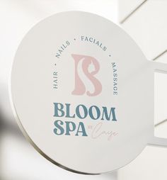 a white sign hanging from the side of a building that says bloom spa on it