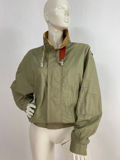 "90s spring jacket, beige jacket, size men's small Measurements:  Shoulder 18\"-21\"/sleeve 22\"/bust (pit-pit)23\"/length 24\"/bottom width 15\"-21\" Mannequin measurements:  5'8\", bust 34\", waist 25\", hip 33\" Please note that vintage clothing sizes can vary greatly.  The Measurements provided  are approximate and are taken lying flat.  I suggest taking a similar garment from your wardrobe and measure it while lying flat.  This way you can compare measurements.  All of our pieces are genuin Luxury Single-breasted Vintage Utility Jacket, Khaki Cotton Windbreaker For Fall, Fall Cotton Khaki Windbreaker, Retro Utility Jacket For Spring Workwear, Retro Spring Utility Jacket For Workwear, Vintage Beige Utility Jacket For Spring, Spring Military Outerwear With Stand Collar, Spring Retro Utility Jacket For Workwear, Khaki Windbreaker For Spring Streetwear