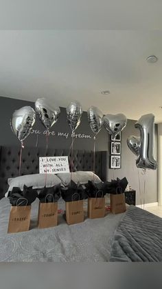 balloons are on the headboard of a bed with black and silver decorations in front of it