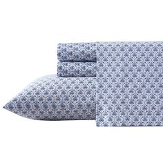 the blue and white sheets are folded on top of each other, with two pillows