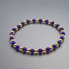 Blue Lapis Lazuli and Gold Beaded Stretch Bracelet Accented with 18K gold filled 4mm beads 4mm deep blue lapis beads A great addition to any bracelet stack. Handmade in Lincoln, Nebraska Blue Stretch Bracelet With Gold Beads, Blue Stretch Bracelet With Gold Round Beads, Gold Stretch Bracelet With Gemstone Beads, Gold Lapis Lazuli Beaded Bracelets With Round Beads, Hand-strung Gold Lapis Lazuli Bracelets, Gold Beaded Lapis Lazuli Bracelets, Gold Rosary Bracelet With Gemstone Beads, Gold Lapis Lazuli Spiritual Bracelets, Gold Lapis Lazuli Bracelets For Gift