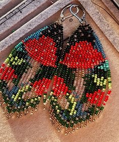 a pair of colorful beaded earrings sitting on top of a table