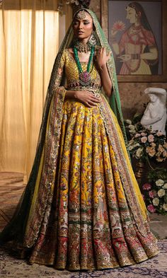 Pakistani Bridal Dress in Yellow Lehenga Choli Style is a classic masterpiece that will give the gorgeous bride a head-turning glamorous look on the most important day of your life. Lavish designs and embellishments give a perfect finishing to this stunning Bridal Lehenga Choli. Lehenga Choli: The choli is in an alluring yellow color is gracefully embellished with intricate designs, zardosi, sequins, tilla, and Resham. Shimmering ornaments, hanging motifs, and lavish contrast of colors make this choli a perfect choice to pair with the Bridal Lehenga. Bridal Lehenga: This Bridal Lehenga is emblazoned with the intricate designs, dabka, tilla, kora, Resham work, sequins, and crystals. The Yellow Lehenga has a huge flare and is adorned with Shimmering details and floral designs, making this Pa Choli Style, Yellow Lehenga Choli, Bridal Lehenga Pakistani, Pakistani Bridal Lehenga, Pakistani Bridal Dress, Yellow Lehenga, Pakistani Wedding Dress, Glamorous Look, Pakistani Bridal Dresses