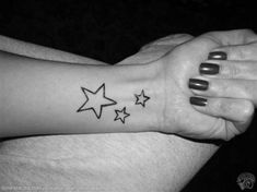 a woman's arm with three stars tattooed on it