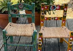 two chairs sitting on top of a wooden deck next to potted plants and flowers