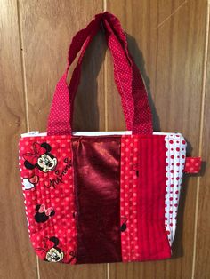 Mini quilted bag/purse for a child I made this cute little bag using various red fabric and one with Minnie Mouse print White Zipper closure - Lined with similar fabric  - no pockets Approximately 7" x 8" with 12" handles Perfect for a child that loves Minnie Mouse! Cute Red Bag With Zipper Pouch, Cute Red Bags With Zipper Pouch, Cute Quilted Bags For Everyday Use, Cute Red Minnie Mouse Bag, Cute Rectangular Minnie Mouse Bags, Rectangular Minnie Mouse Bag For Everyday Use, Red Minnie Mouse Bag For Daily Use, Cute Red Bag With Removable Pouch, Cute Red Bags With Removable Pouch