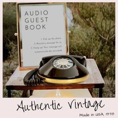 an old fashioned phone sitting on top of a table next to a sign that reads authentic vintage