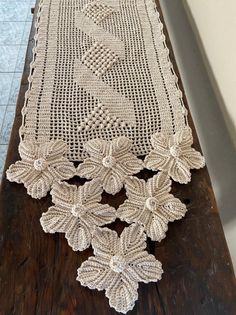 a table runner with crocheted leaves on it