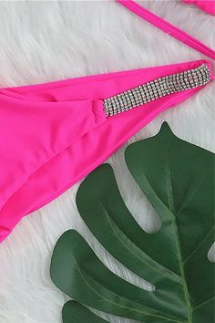 This hot neon pink bikini set is a must-have for beach days. It features a rhinestone embellished triangle top with sliding cups, halter tie, and double back tie straps. The top is padded with removable pads for your comfort. The strappy design gives it a chic look. The high leg bikini bottom has a Brazilian thong cut with a ruched back, offering a flattering fit. The sides are trimmed with rhinestones, adding extra sparkle. Made from stretchy, lined material, this bikini is perfect for showing off your style at the beach. Hot neon pink color for a vibrant look Rhinestone embellished triangle top Sliding cups for adjustable coverage Halter tie with double back tie straps Padded top with removable pads for customizable fit Strappy design adds a chic touch High leg bikini bottom with Brazili Party Swimwear With Rhinestones For Beach Season, Summer Rhinestone Swimwear For Poolside, Rhinestone Swimwear For Poolside In Summer, Rhinestone Swimwear For Poolside And Beach Season, Rhinestone Swimwear For Summer Poolside, Beachwear Swimwear With Rhinestones For The Beach, Party Beachwear With Rhinestones, Beachwear Swimwear With Rhinestones For The Pool, Summer Poolside Swimwear With Rhinestones