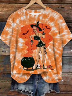 an orange and black tie dye shirt with a woman wearing a witches costume on it